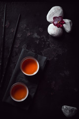 Asian tea ceremony. Chinese ceramic tea cups on stone dark background