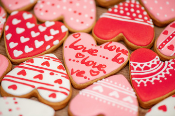 Gingerbread hearts festive on Valentine's Day. Delicious and sweet, covered with icing with a beautiful pattern, handmade. Top view.  Macro.