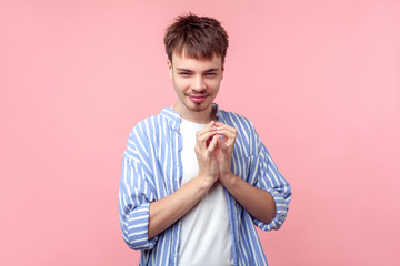 Portrait of funny tricky brown-haired man with small beard and mustache in casual striped shirt...