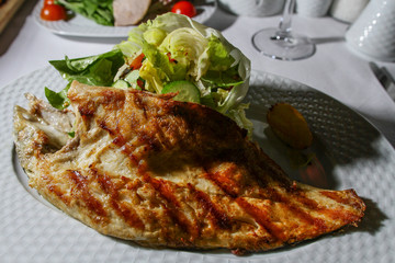 A plate with fried fish, vegetable and lemon