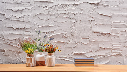 Grey textured wall background and home design vase of flower book and frame on the wood desk interior.