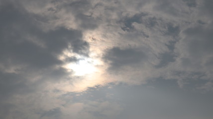 Naklejka na ściany i meble Grey white black monsoon clouds. Sun hidden in the sky.