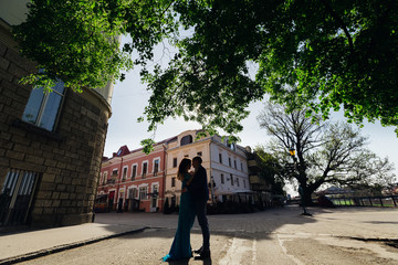Fototapeta na wymiar The guy and the girl embraced each other on the city square amon