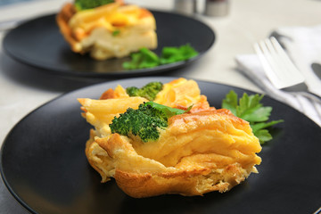 Tasty broccoli casserole on dark plate, closeup