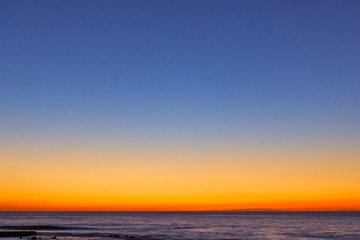 Orange-blue serene sky over the sea at sunset