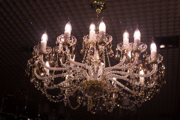 Vintage expensive luxury chandelier on a store window. Shop of lamps and fixtures.