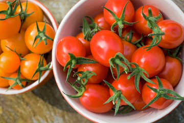 A fresh harvest of home grown miniature tomatoes in ceramic bowls.