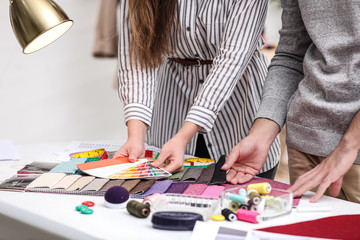 Fashion designers creating new clothes in studio, closeup
