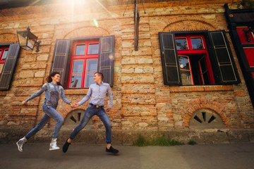 couple running fast neat brick building with red windows