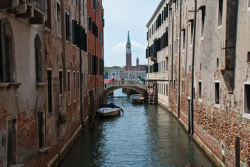 Venice, Italy: traditional buildings, canal Rio de la Pleta, district Castello, tower of church San Giorgio Maggiore in the background