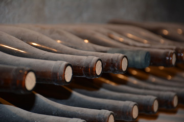 Very old and dusty wine bottles in storage cellar