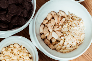 top view of nutritious nuts near chocolate chips in bowls