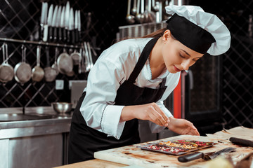 attractive chocolatier looking at dark chocolate bars