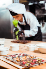 selective focus of chocolate bars near chocolatier holding pastry bag
