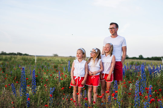 Father and daughters on meadow