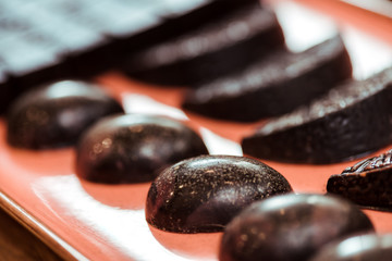 selective focus of sweet dark chocolate candies on plate