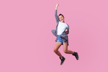Fototapeta I did it! Energetic teen girl with bun hairstyle in casual clothes jumping with closed eyes and raised fists, crazy about winning, screaming and dancing with happiness in the air, celebrating success obraz