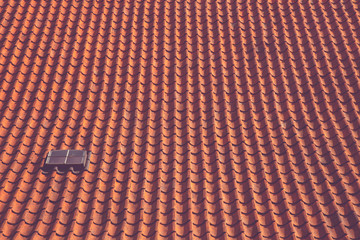 Background of brown clay roof tiles with window. Red old roof and old roof tiles. Construction equipment.
