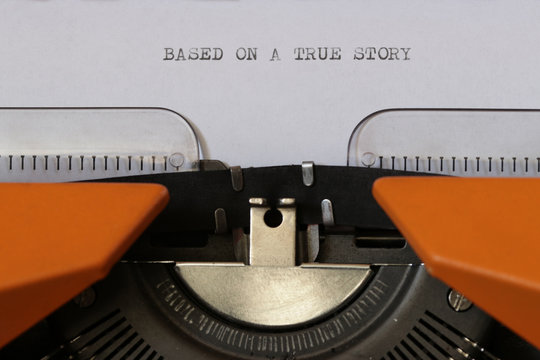 Close up footage of ˝BASED ON A TRUE STORY˝ written on a paper, on an old typewriter with capital letters...