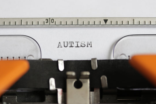 Close up footage of the word AUTISM written on a paper, on an old typewriter with capital letters...