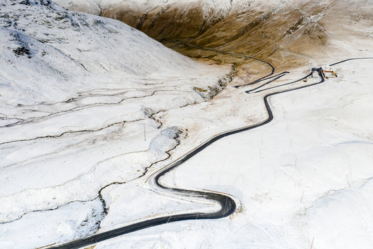 Aerial view by drone of S-shape road towards Stelvio Pass in the snowy landscape, Bormio, Sondrio province, Valtellina, Lombardy