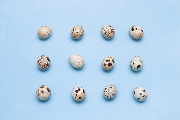Pattern of quail eggs on a blue background. proper nutrition concept. easter background, minimalism,top view