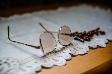 Wooden rosary and glasses of an elder on the white blanket, on the wooden table. Orthodox old believer concept background.