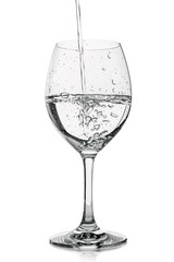 Pour water into clear glass. Drinking water pouring in wine glass. Splash of water in glass on white background with bubbles. Studio shot. Water is the basis of life. Concept of a healthy lifestyle. W