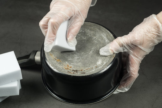 Hands In Gloves Cleaning Old Pot With Eco Friendly Magic Sponge, No Detergent House Cleaning