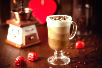 Chocolate coffee cream mousse three chocolates and whipped cream in a tall glass glass on a wooden background. Delicious sweet dessert. Soft focus