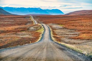 A sloping dirt road against a hill with vanishing point, Husavik, Iceland