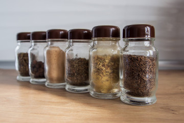 Row of spice jars containing various herbs and spices