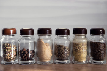 Row of spice jars containing various herbs and spices