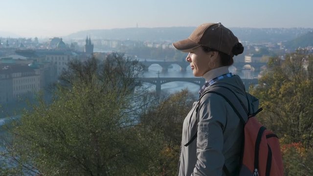 View on Prague bridges. A tourist girl enjoys the panorama of the Prague bridges in the autumn morning.