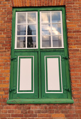 Grüne Fensterläden in Backstein