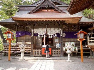 worshiper rings a bell at arakura sengen shrine in japan