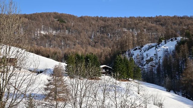San Sicario, Piedmont, Italy. December 2019. View on the cableway leading to the ski slopes. We recognize the small cabins that flow in both directions. Winter landscape. Vacation concept.