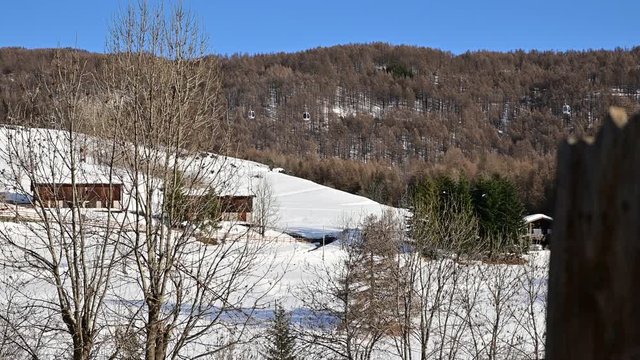 San Sicario, Piedmont, Italy. December 2019. View on the cableway leading to the ski slopes. We recognize the small cabins that flow in both directions. Winter landscape. Vacation concept.