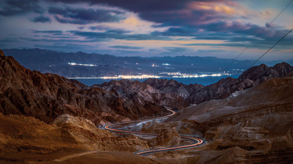 eilat israel red sea high mountains landscape with curvy road vehicle light trails long exposure...