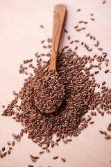 Close up Flax seeds in a wooden spoon. Healthy food background.