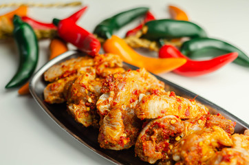 Raw and fresh chicken wings in a siriracha marinade