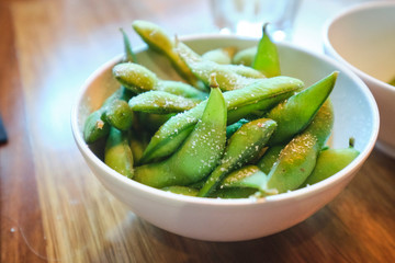 Edamame beans in Japanese restaurant in bowl with chopsticks