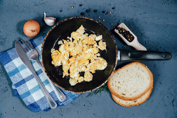 Top view Scrambled eggs in a pan on a stone counter. The concept of preparing a meal of eggs, scrambled eggs.