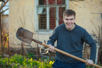 Agronomist handsome strong man with shovel on  background of flower beds © solstizia