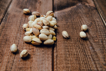 Nuts pistachios on a wooden background. The concept of eating nuts, giving them to a meal.