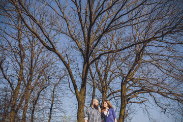 A girl and a guy are walking in the park. Portrait of a couple, a love story.Happy smiling, loving couple together outstretched at beautiful nature.