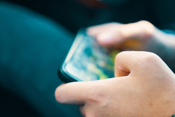 Mobile gaming concept. Man holding smartphone and playing in game.