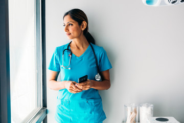 Nurse looking at mobile phone in medical room