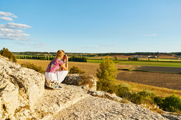 Young woman taking a picture of the landscape and countryside of the provence in France
