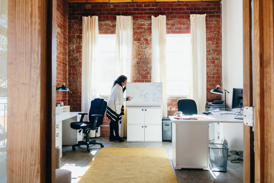 Woman erasing whiteboard before meeting